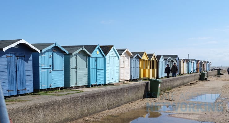 beach huts blue skies